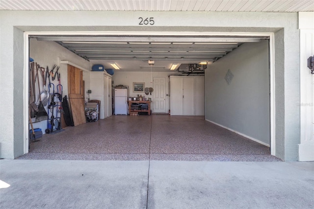 garage with a garage door opener and white fridge