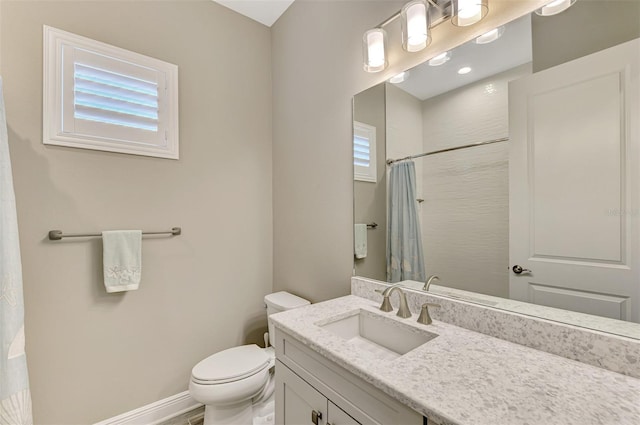 full bathroom with vanity, a shower with shower curtain, toilet, and a wealth of natural light