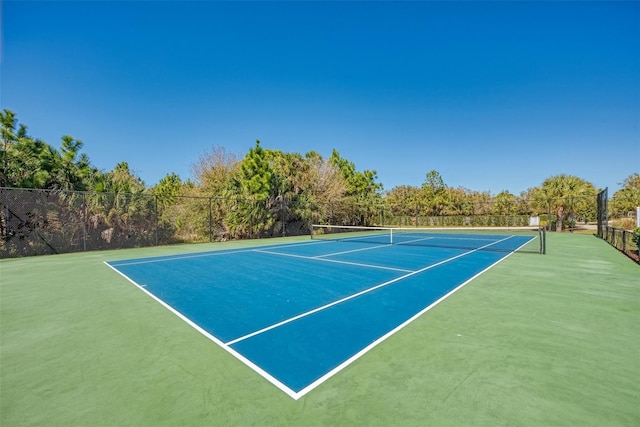 view of tennis court featuring fence