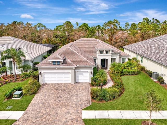 mediterranean / spanish house with a front lawn and a garage