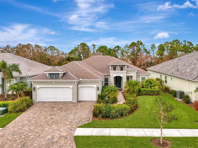 mediterranean / spanish-style home with a garage, central AC, and a front lawn