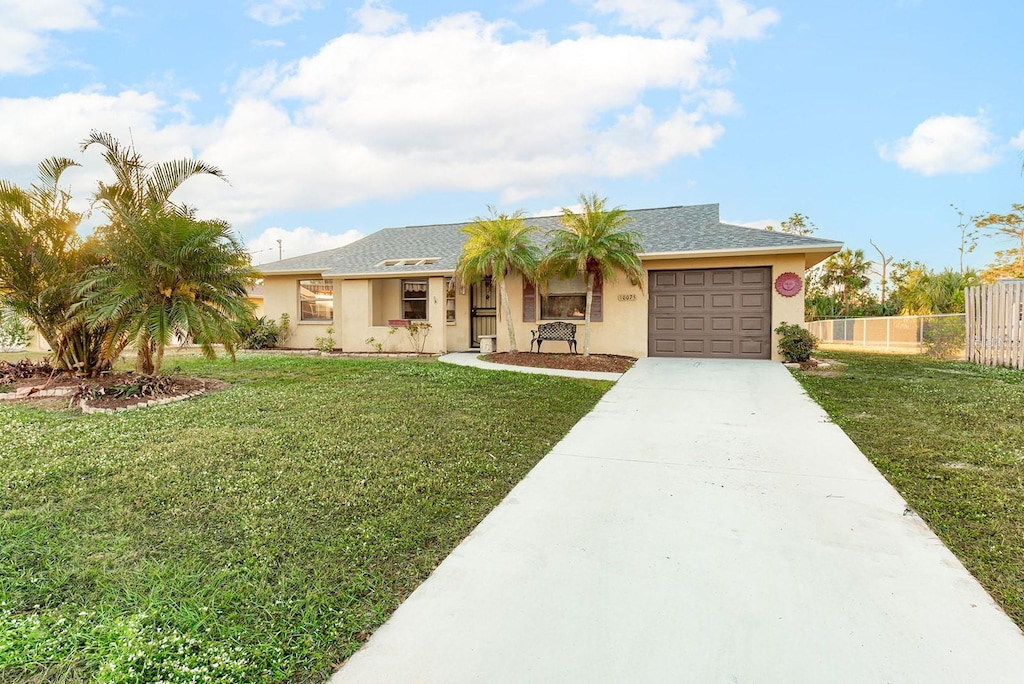 ranch-style home featuring a front lawn and a garage