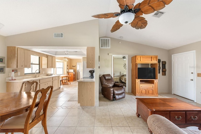 dining area featuring ceiling fan, sink, light tile patterned flooring, and vaulted ceiling