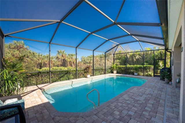 view of pool with a patio and glass enclosure