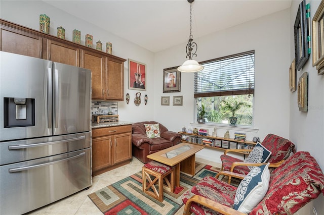 kitchen featuring hanging light fixtures, light tile patterned flooring, stainless steel fridge, and tasteful backsplash