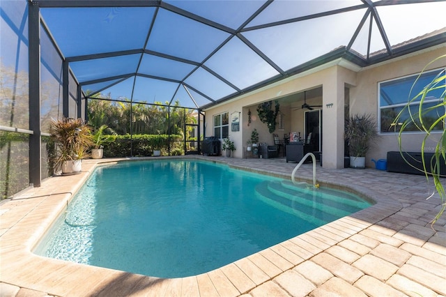 view of pool featuring glass enclosure, ceiling fan, and a patio area