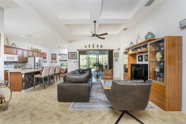 tiled living room featuring beamed ceiling, ceiling fan, and coffered ceiling