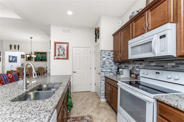 kitchen featuring light stone counters, decorative backsplash, sink, light tile patterned flooring, and white appliances