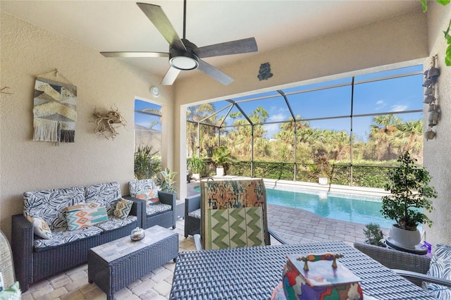 view of patio featuring glass enclosure, an outdoor living space, and ceiling fan