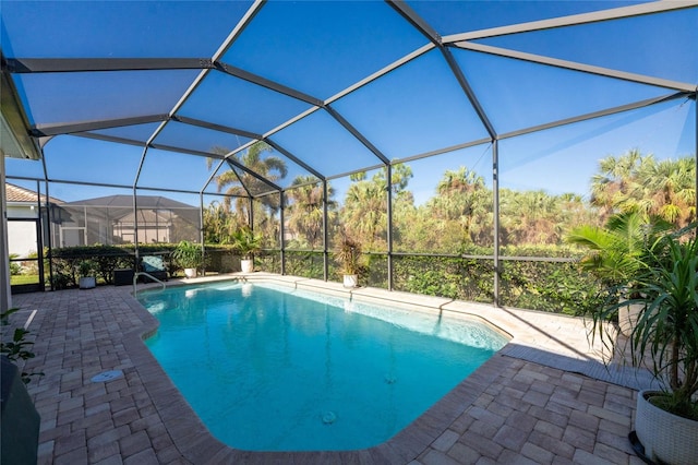 view of swimming pool with glass enclosure and a patio area