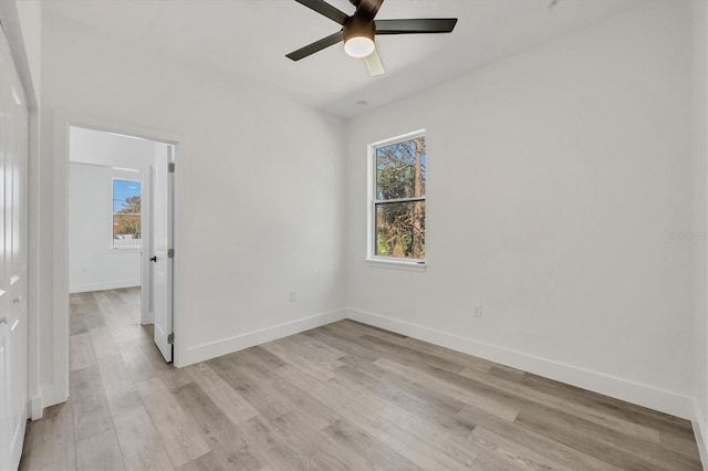 empty room with light hardwood / wood-style floors, ceiling fan, and a wealth of natural light