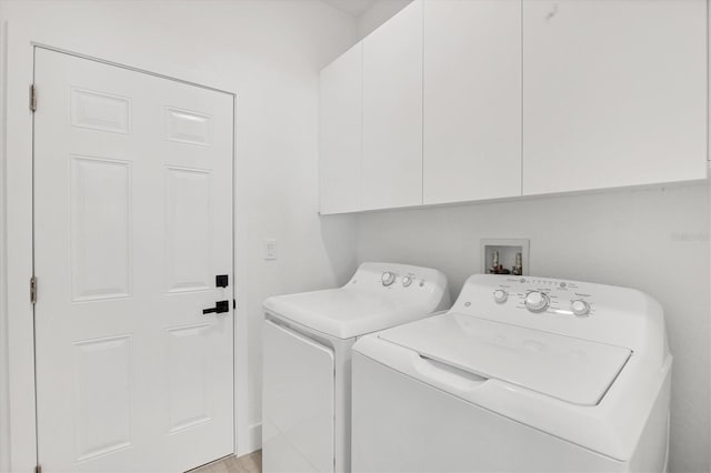 laundry area with washing machine and dryer and cabinets