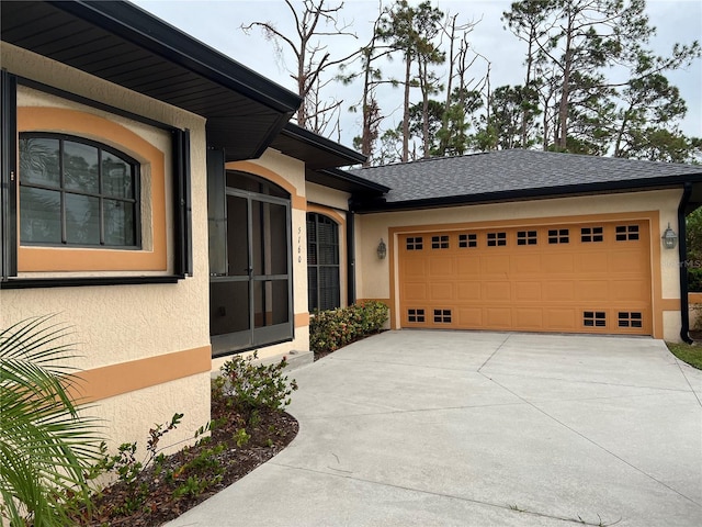 exterior space with concrete driveway, a garage, roof with shingles, and stucco siding