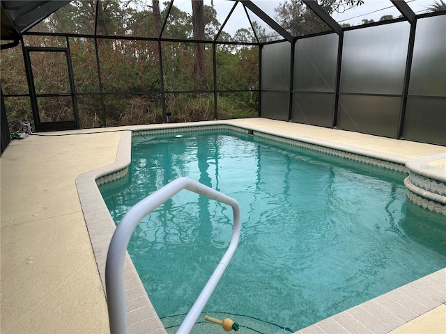 outdoor pool featuring glass enclosure and a patio