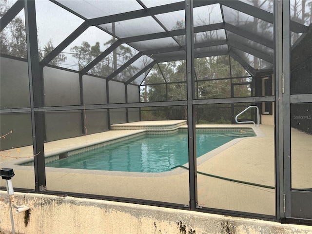 view of pool with a patio and glass enclosure