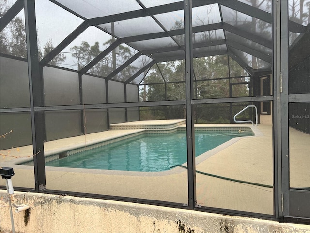 pool with glass enclosure and a patio area