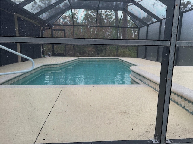 view of swimming pool with a patio and glass enclosure