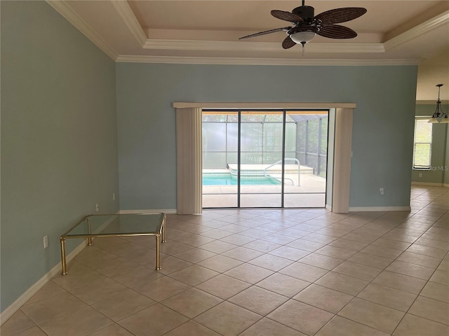 tiled spare room with a raised ceiling, ornamental molding, and ceiling fan