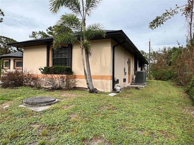 view of home's exterior featuring central AC unit and a lawn