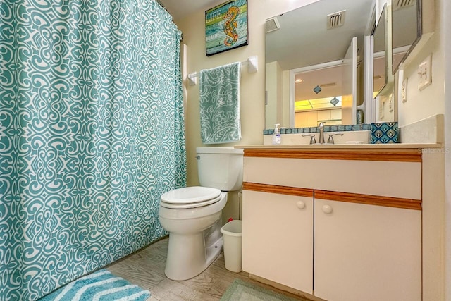 bathroom featuring vanity, hardwood / wood-style flooring, and toilet