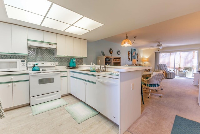 kitchen with white appliances, ceiling fan, kitchen peninsula, and white cabinets