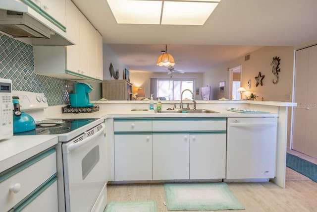 kitchen with white cabinets, hanging light fixtures, light hardwood / wood-style flooring, sink, and white appliances