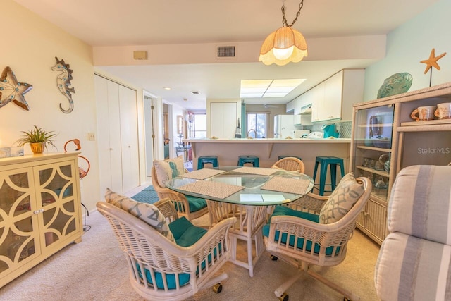 dining space featuring light carpet