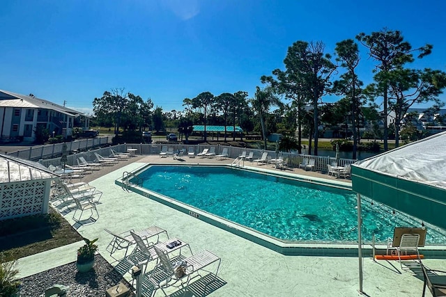 view of pool featuring a patio and a water view