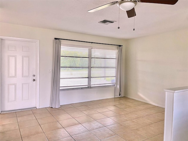 spare room with light tile patterned flooring and ceiling fan