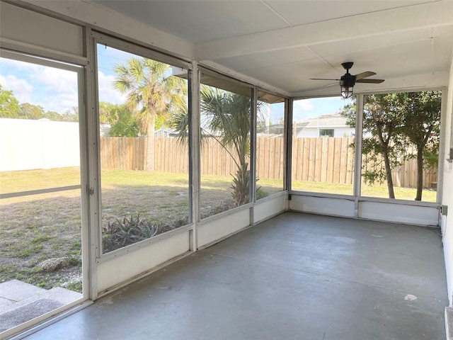 unfurnished sunroom featuring ceiling fan