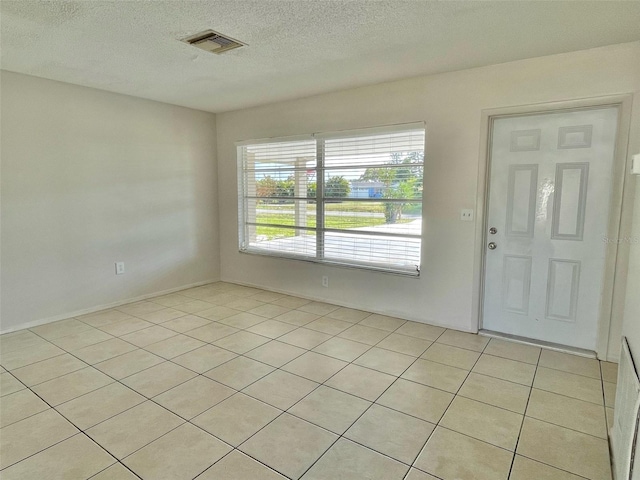 tiled entryway with a textured ceiling