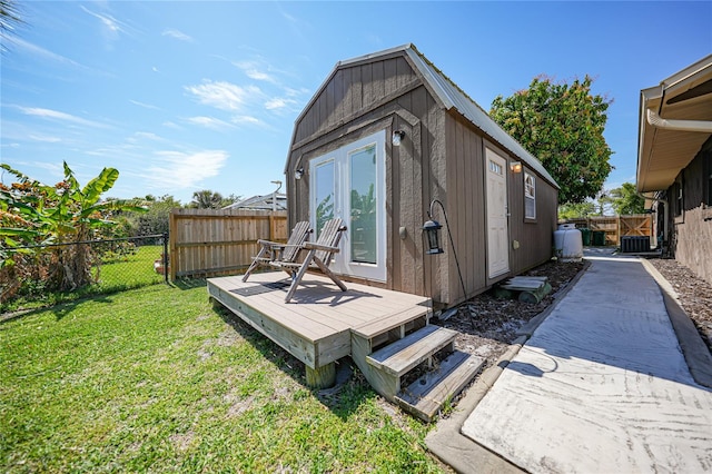 rear view of house featuring a yard, a shed, and a wooden deck