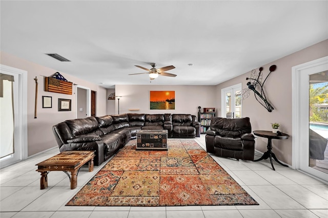 tiled living room featuring french doors, a healthy amount of sunlight, and ceiling fan