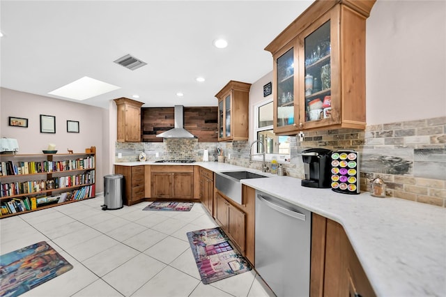 kitchen featuring tasteful backsplash, sink, wall chimney exhaust hood, gas stovetop, and stainless steel dishwasher