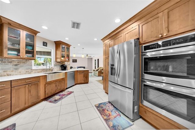 kitchen with ceiling fan, light tile patterned floors, stainless steel appliances, sink, and decorative light fixtures