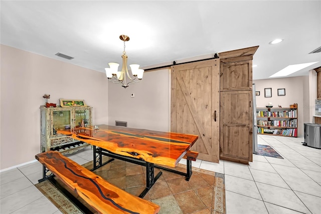 tiled dining room featuring an inviting chandelier and a barn door