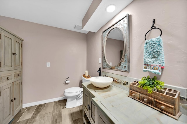 bathroom with vanity, hardwood / wood-style flooring, and toilet