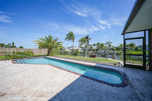 view of swimming pool with a water view and a patio