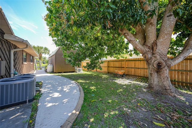 view of yard featuring central air condition unit, a storage shed, and a patio