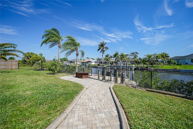 view of dock with a yard and a water view