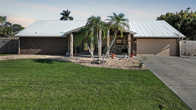 view of front of home with a garage and a lawn