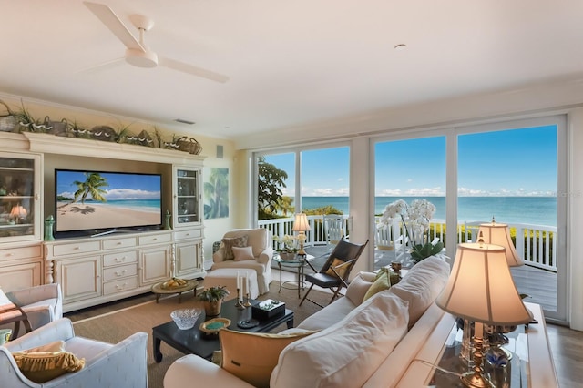 living room featuring hardwood / wood-style floors, a water view, a wealth of natural light, and ceiling fan