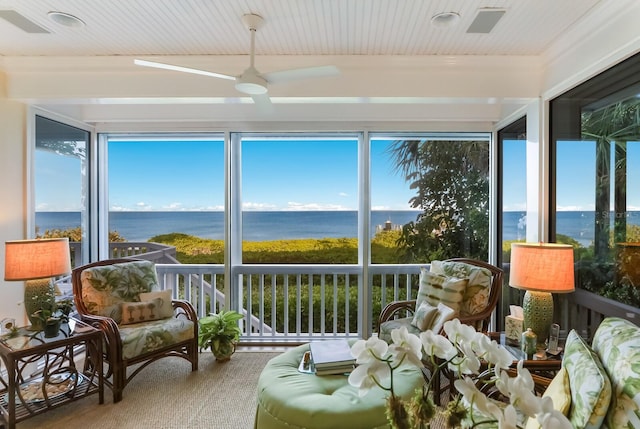 sunroom featuring a water view and ceiling fan