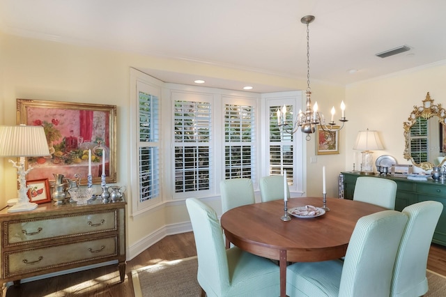 dining area featuring an inviting chandelier, dark wood-type flooring, and ornamental molding