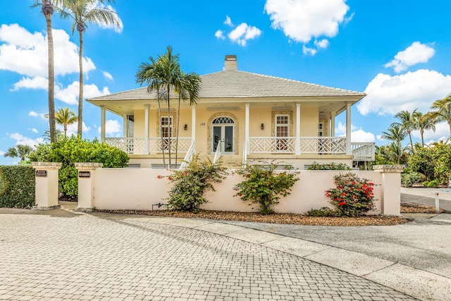 view of front of home featuring covered porch and french doors