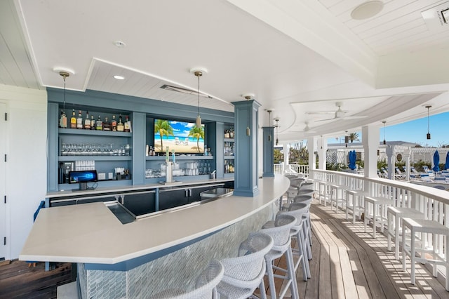 bar featuring ceiling fan, pendant lighting, dark hardwood / wood-style floors, and built in shelves