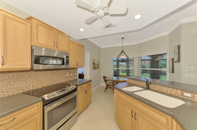 kitchen featuring appliances with stainless steel finishes, tasteful backsplash, ornamental molding, ceiling fan with notable chandelier, and sink