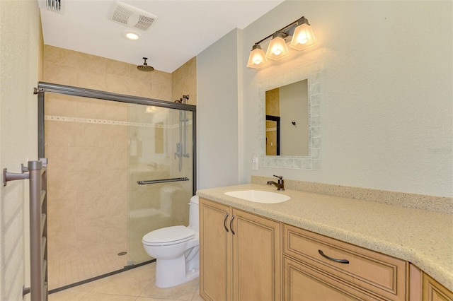 bathroom with tile patterned floors, vanity, toilet, and a shower with shower door