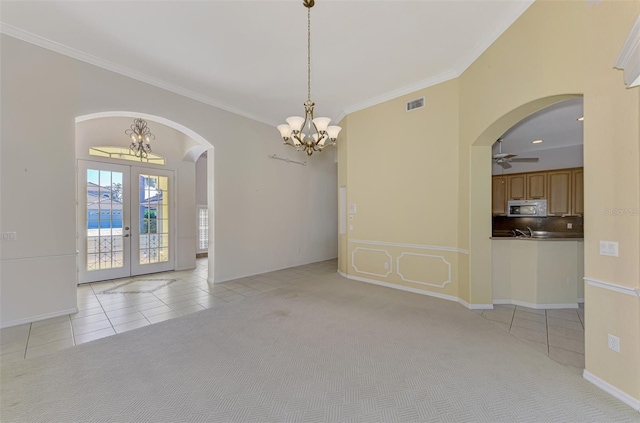 spare room featuring french doors, ornamental molding, ceiling fan with notable chandelier, and light tile patterned floors