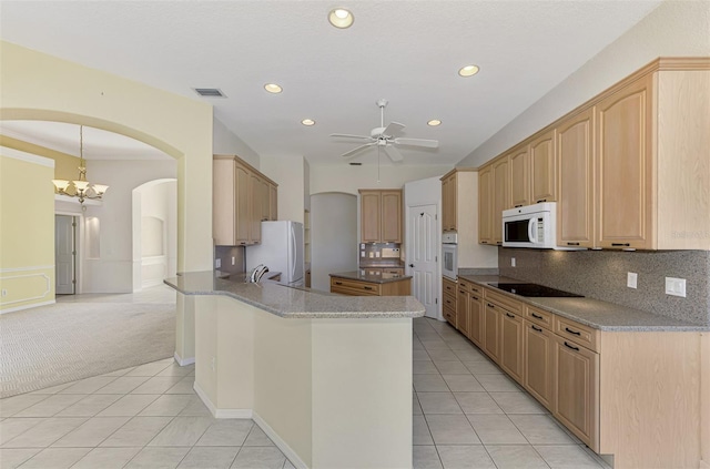 kitchen featuring kitchen peninsula, tasteful backsplash, light tile patterned floors, ceiling fan with notable chandelier, and white appliances